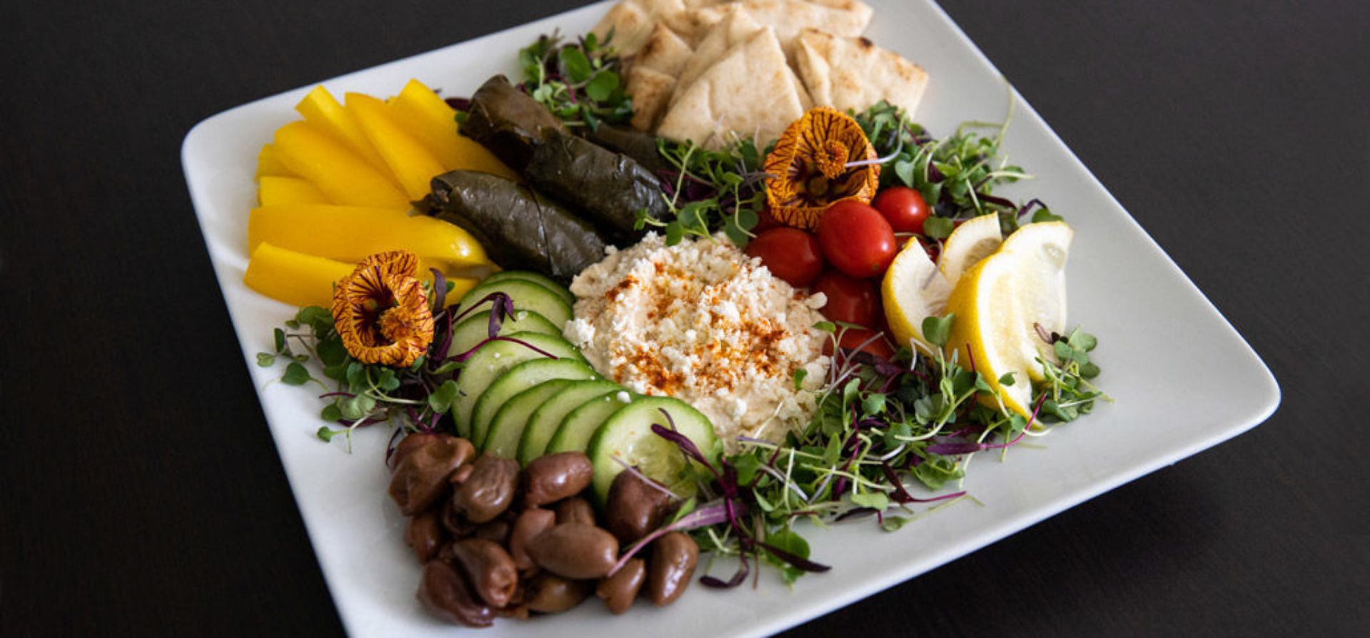 Colorful platter with vegetables, pita, and hummus, Inn at Bay Harbor amenities.