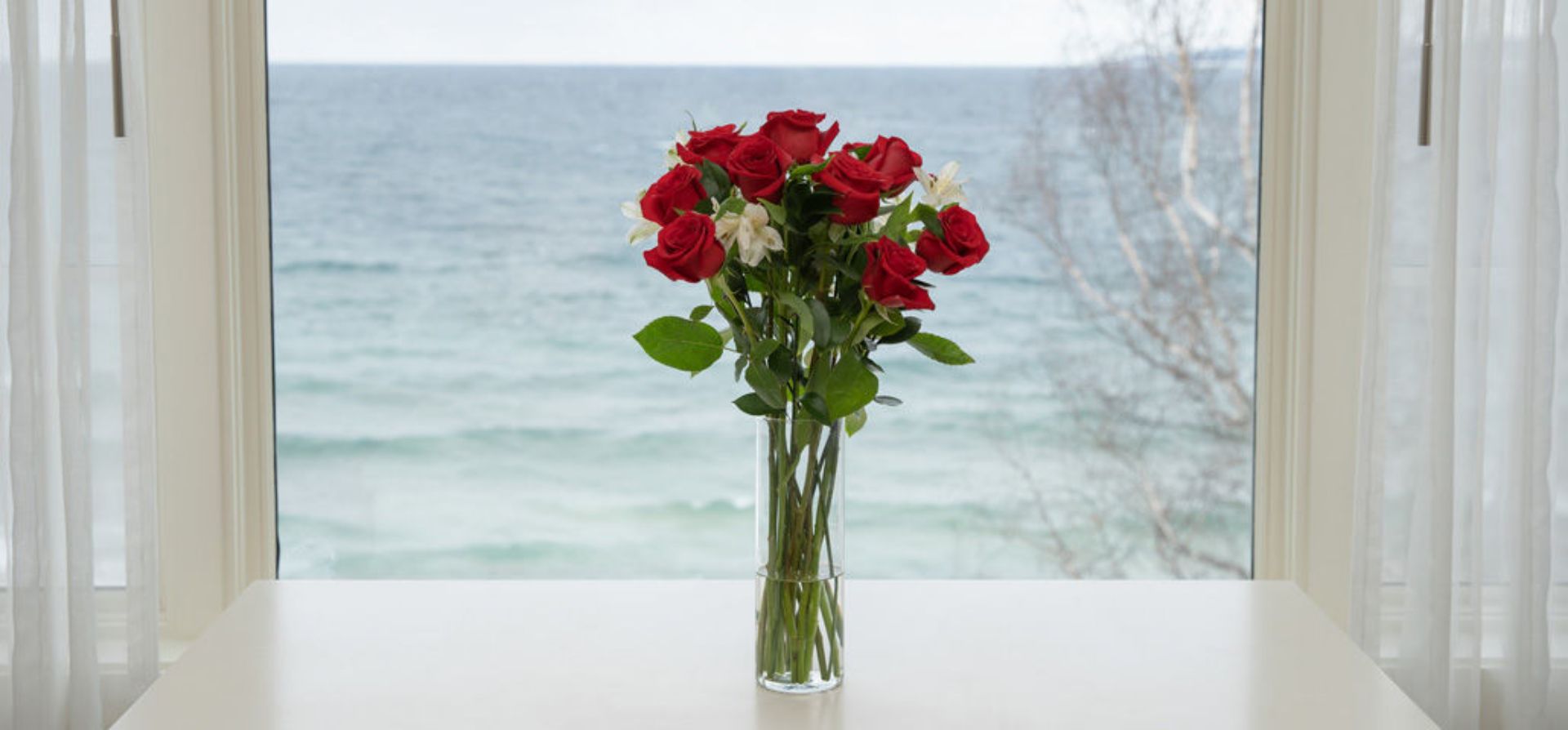 Dozen red roses in lakefront window, Inn at Bay Harbor